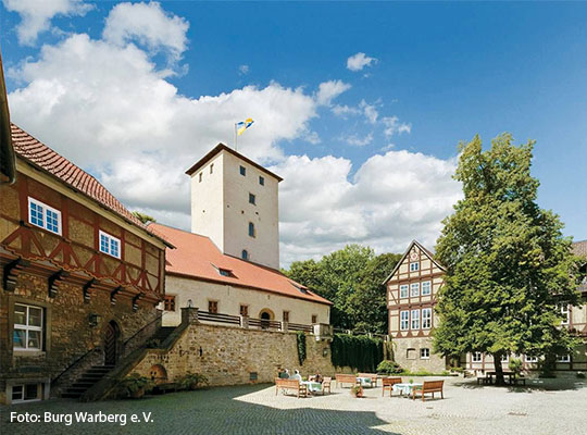 Ansicht eines Hofes auf dem Tische mit Stühlen stehen